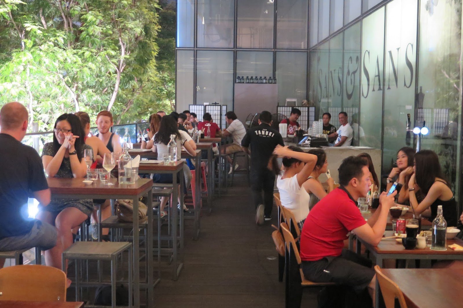 Tanuki Raw busy balcony dining at night — Orchard Central Singapore happy hour