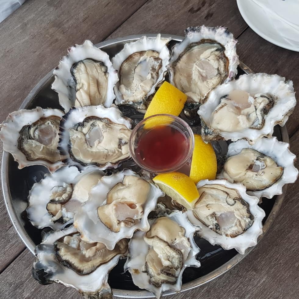 Fresh oysters on the half shell with lemon and mignonette — Tanuki Raw happy hour Singapore
